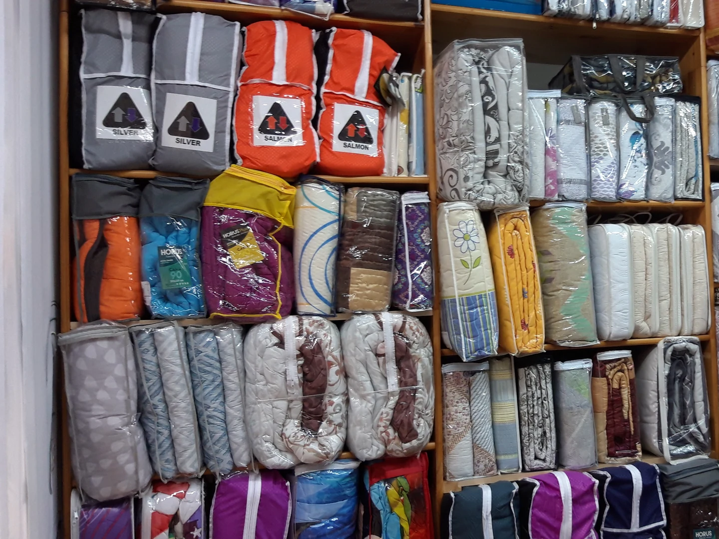 Ropa de cama presentada en estanterías de la tienda Rederi